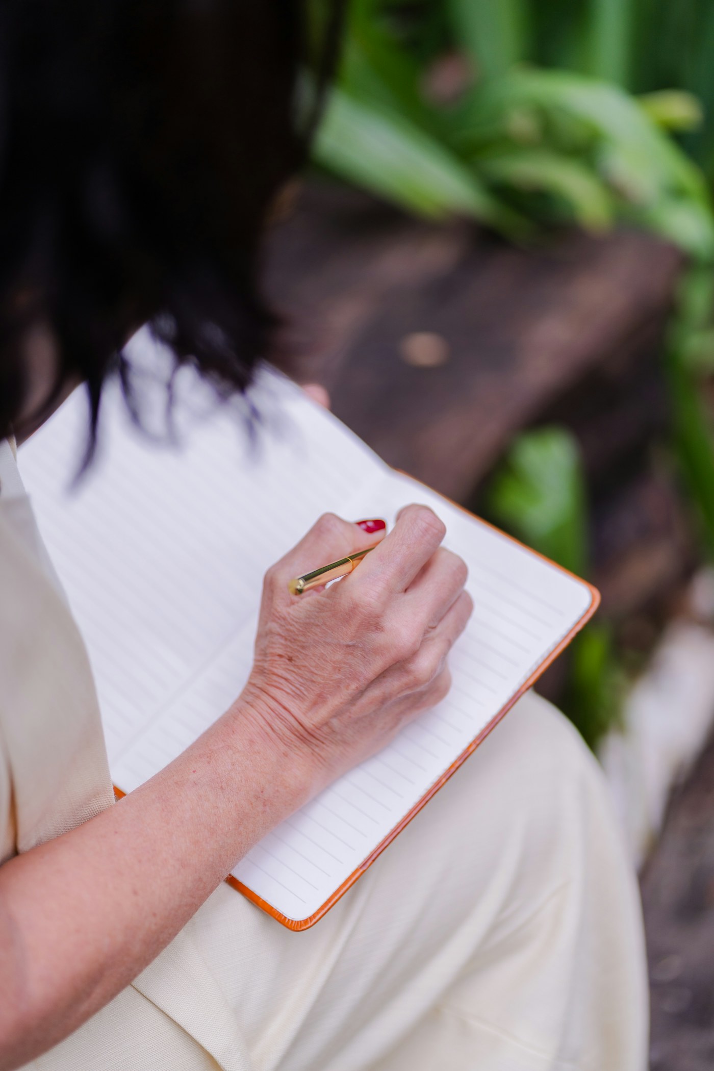 Writing down questions in a notebook outdoors