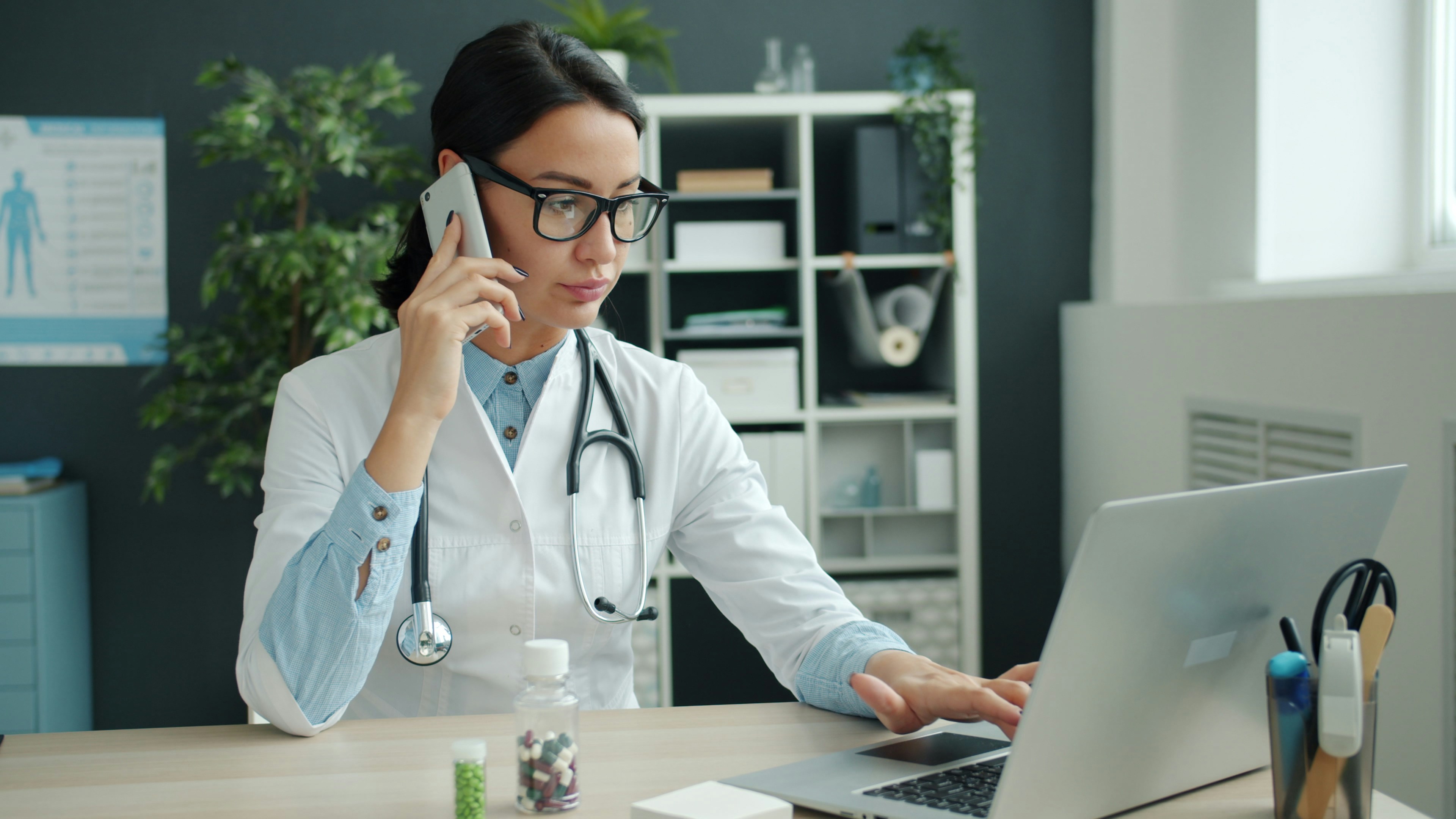 Healthcare provider speaking on the phone at her desk